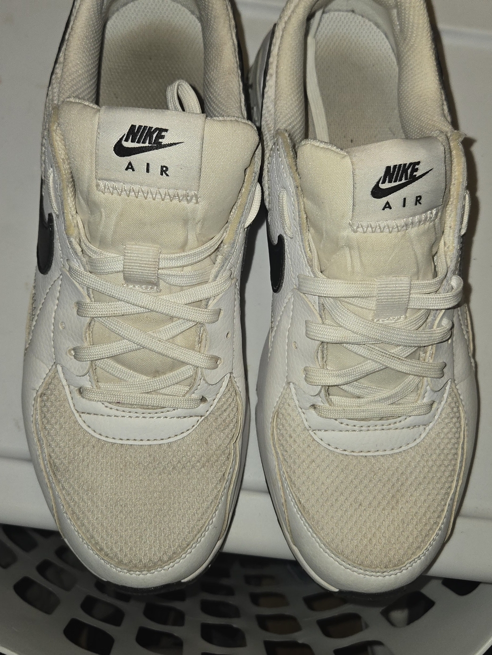 Nike Air Max Excee sneakers with black swooshes.